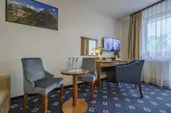 Hotellihuone, jossa on pieni pöytä ja työpöytä